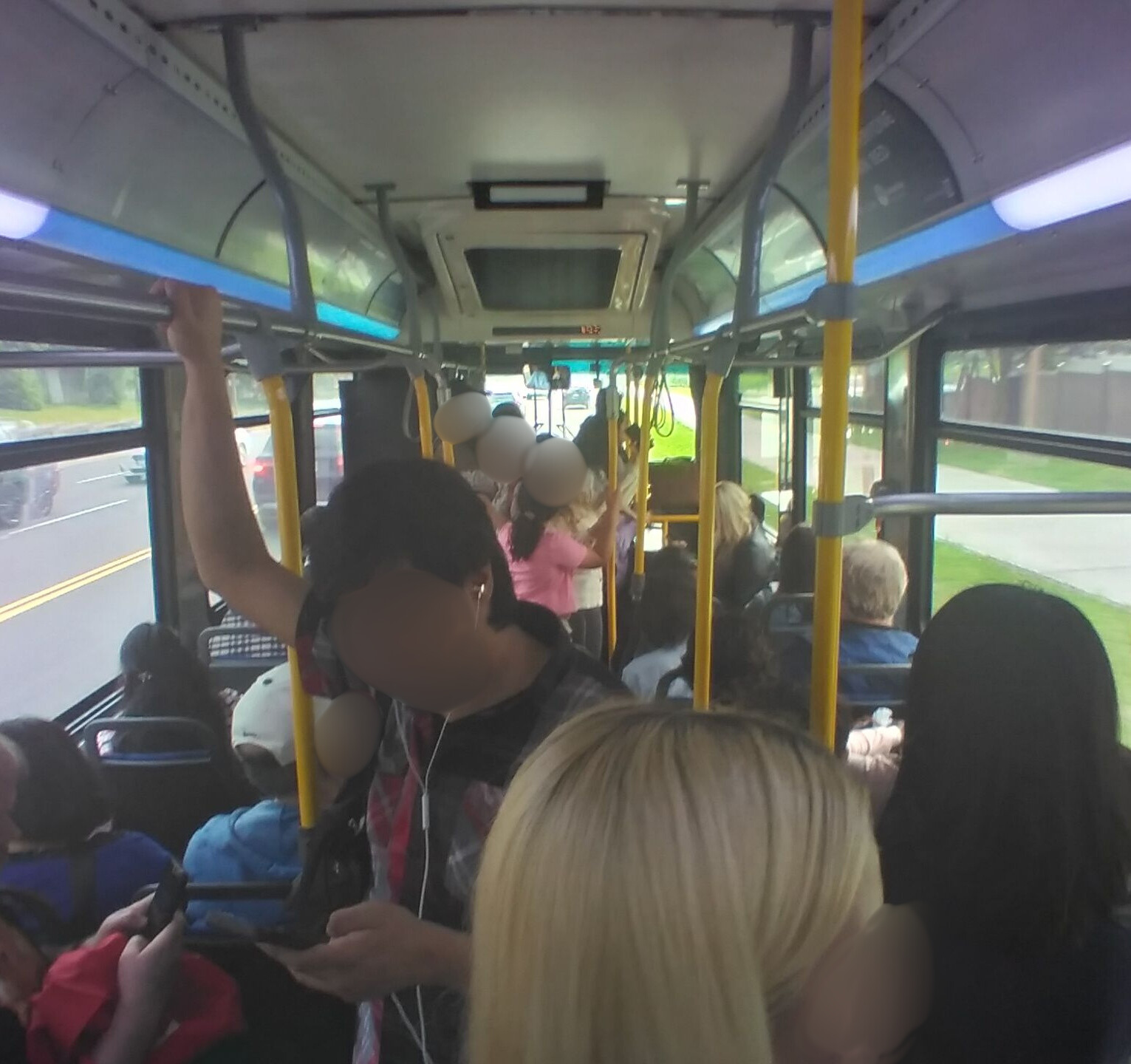 The inside of a bus with several people standing. There was one 
        more person on board than provincial regulations allow.